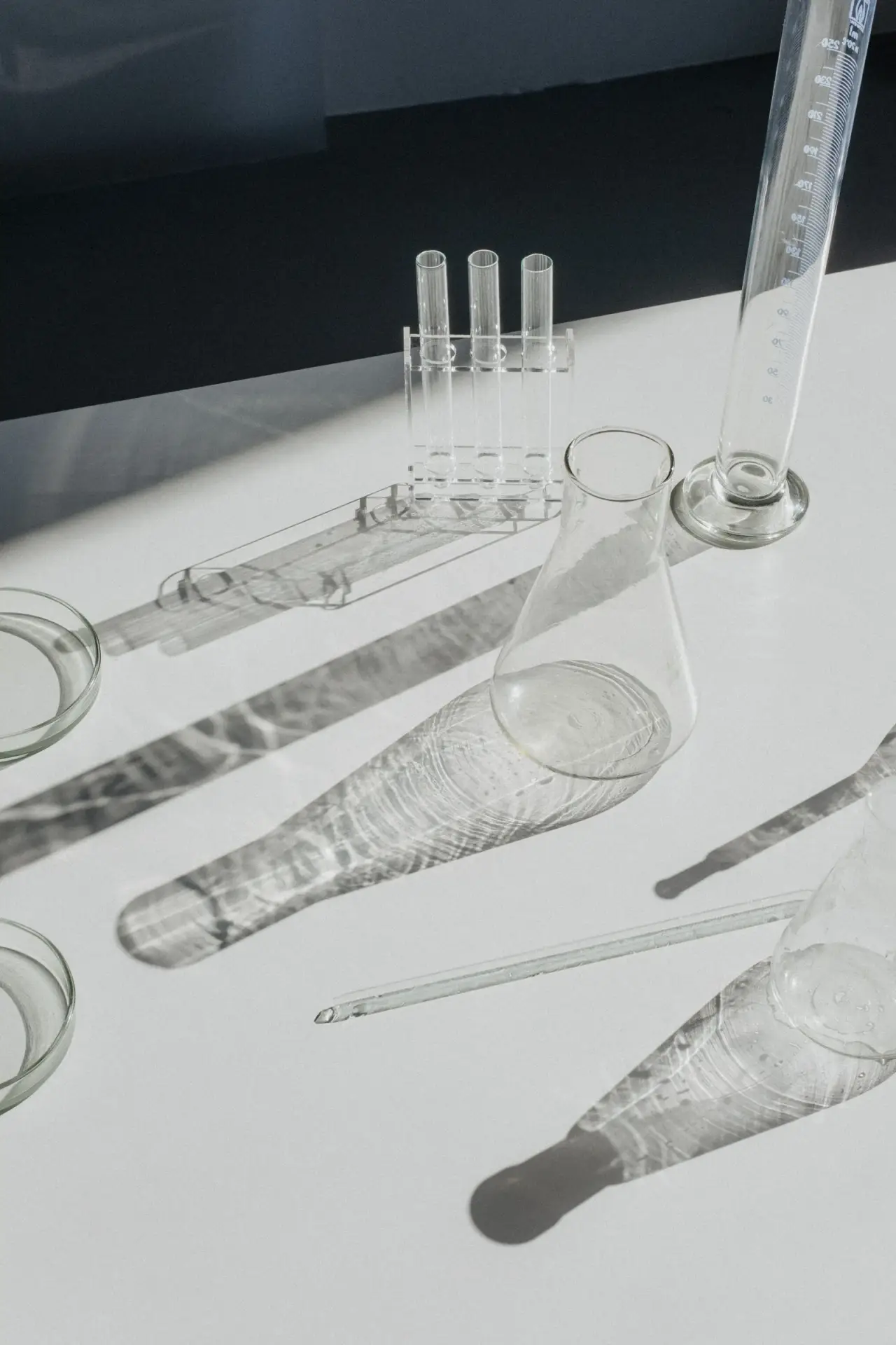 Verrerie de laboratoire, ombres et lumière sur table blanche